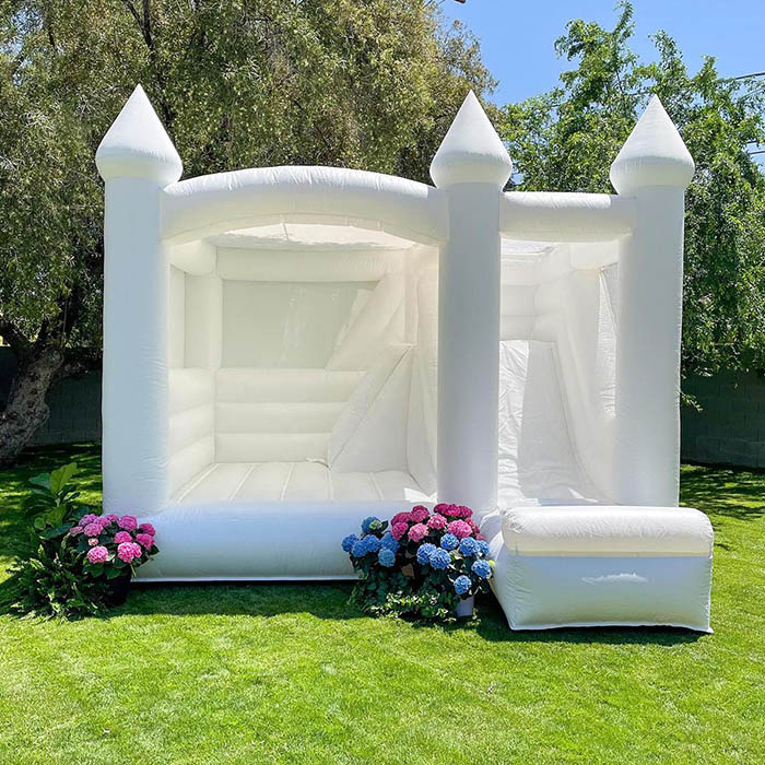 A white bounce house with some flowers decoration